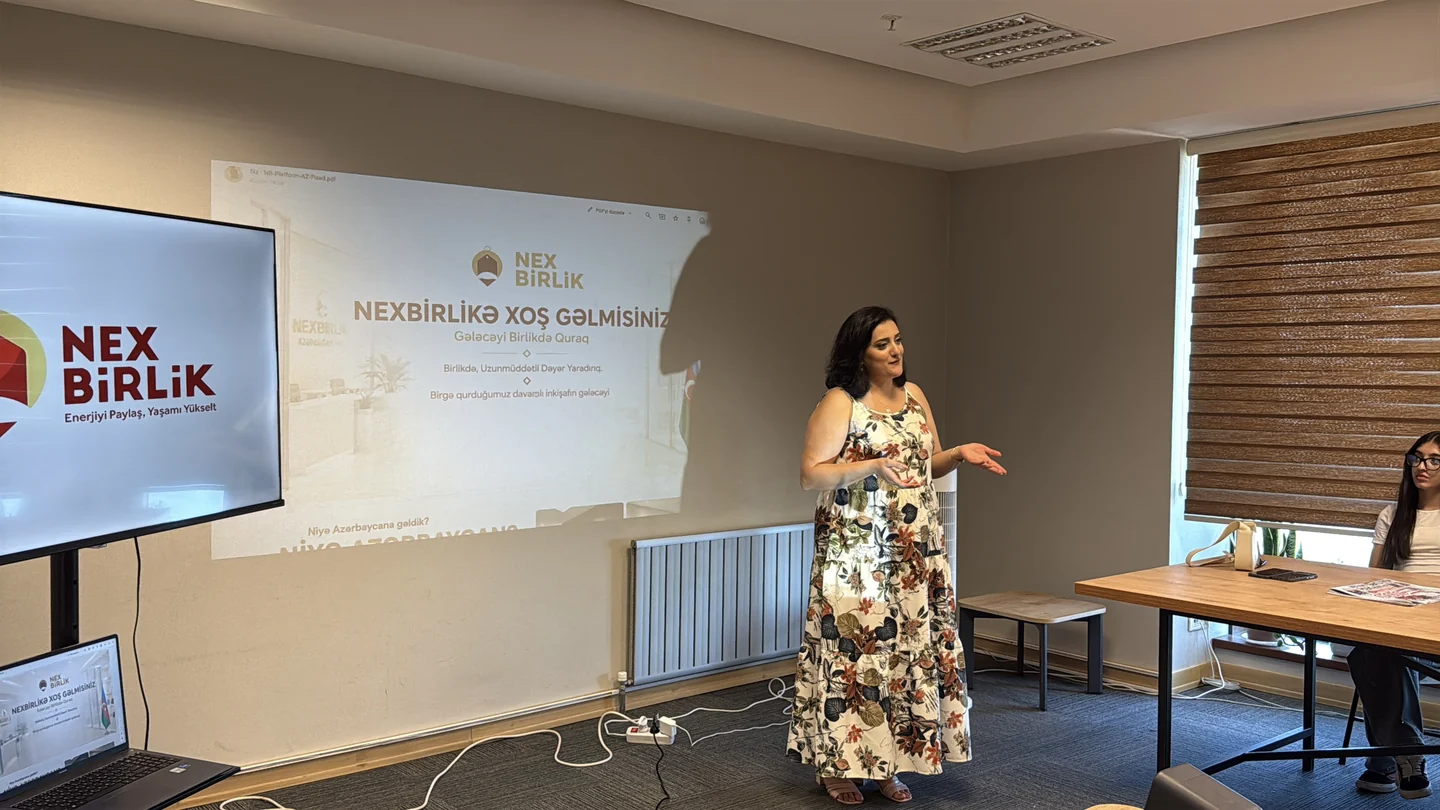 NexBirlik ekranının yanında konuşan bir kadın