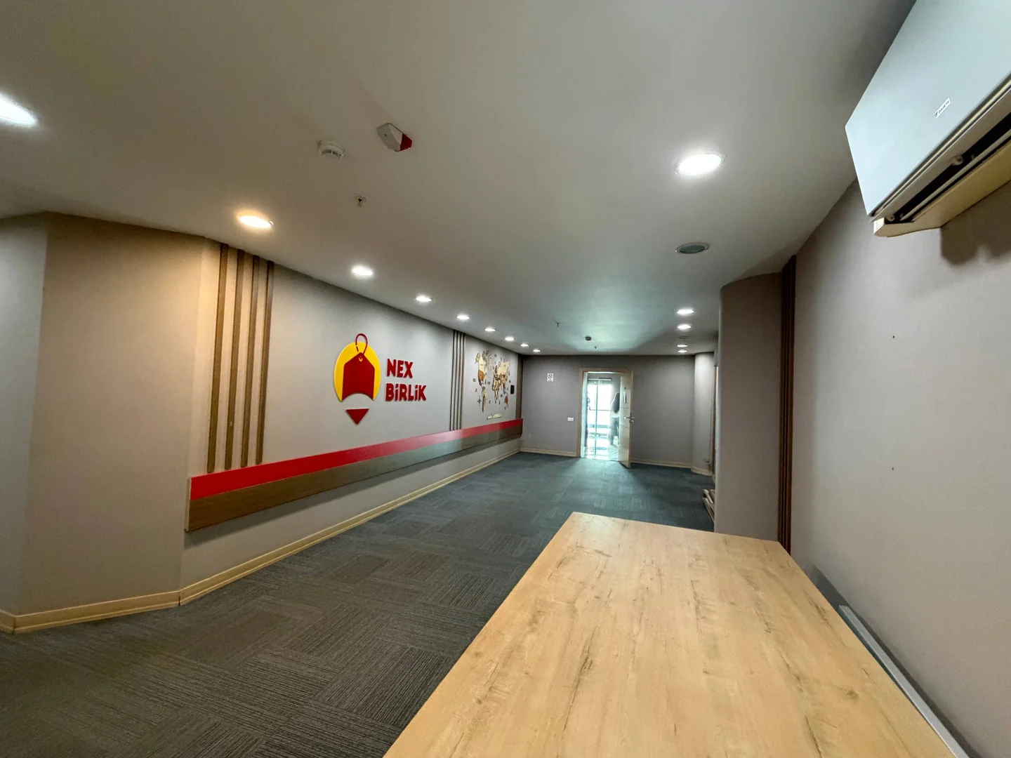 NexBirlik logosu bulunan boş ofis koridoru