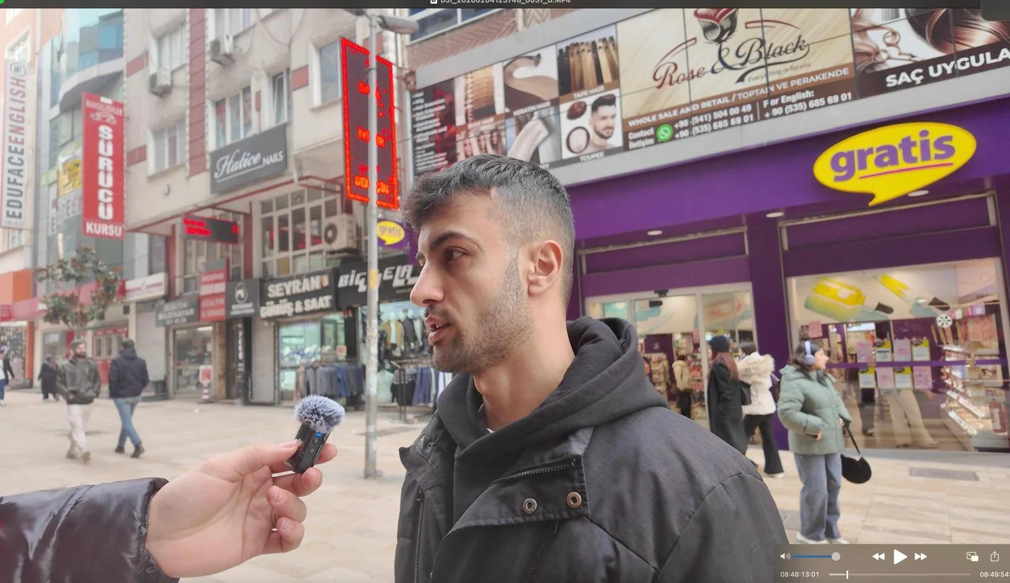 Sokakta mikrofona konuşan bir kişi